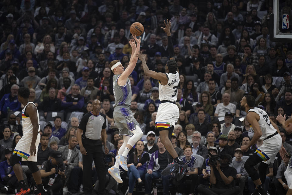 Sacramento Kings guard Kevin Huerter, center left, shoots over Minnesota Timberwolves forward Jaden McDaniels (3) in the first quarter in an NBA basketball game in Sacramento, Calif., Monday, March 27, 2023. (AP Photo/José Luis Villegas)