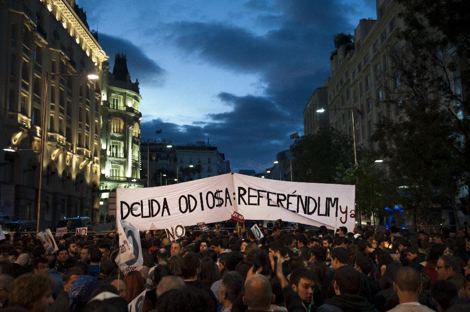 Protestors gather near Parliament demonstrating against austerity measures announced by the Spanish government in Madrid, Spain, Saturday, Sept. 29, 2012. Tens of thousands of Spaniards and Portuguese rallied in the streets to protest enduring deep economic pain from austerity cuts. In Madrid, demonstrators approached parliament for the third time this week to vent their anger against tax hikes, government spending cuts and the highest unemployment rate among the 17 nations that use the euro. Banner reads 'Hate debt, referendum'.(AP Photo/Daniel Ochoa De Olza)