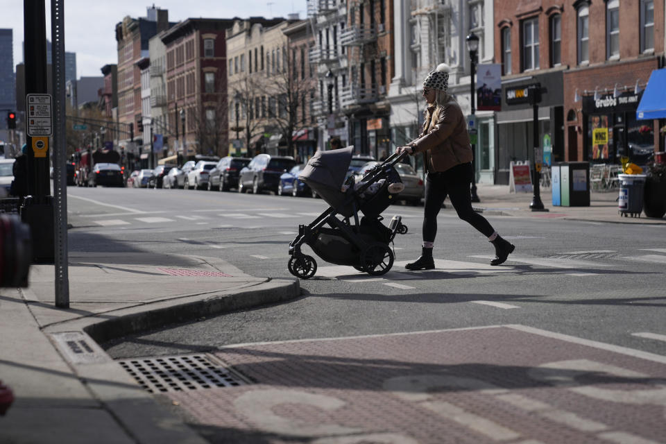 Pedestrians cross the street at the intersection of Washington and 5th in Hoboken, N.J., Thursday, Feb. 22, 2024. This intersection has curb extenders, left, which bumps out the sidewalk near crosswalks, preventing parking near the intersection and increasing visibility for pedestrians. (AP Photo/Seth Wenig)