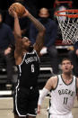 Brooklyn Nets center DeAndre Jordan (6) dunks the ball in front of Milwaukee Bucks center Brook Lopez during the first half of an NBA basketball game Monday, Jan. 18, 2021, in New York. (AP Photo/Adam Hunger)