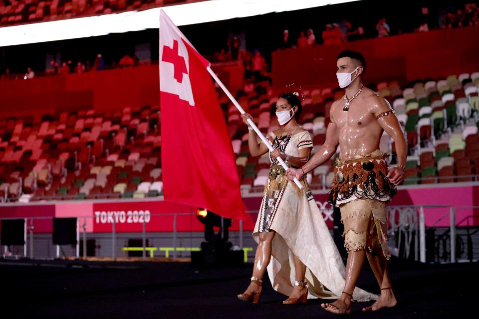 Flag bearers Malia Paseka and Pita Taufatofua lead Team Tonga during the opening ceremony.