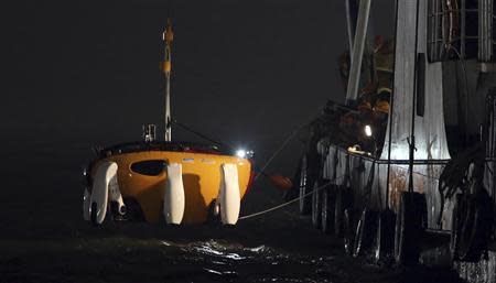 A South Korean rescue ship drops a 'Crabster' robot, which is designed to work up to 200 metres below the surface, into the sea during a search and rescue operation for missing passengers of the capsized passenger ship Sewol which sank last Wednesday, in the sea off Jindo, April 22, 2014. REUTERS/Yonhap