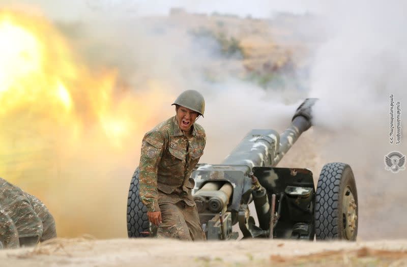 An ethnic Armenian soldier fires an artillery piece during fighting with Azerbaijan's forces in Nagorno-Karabakh