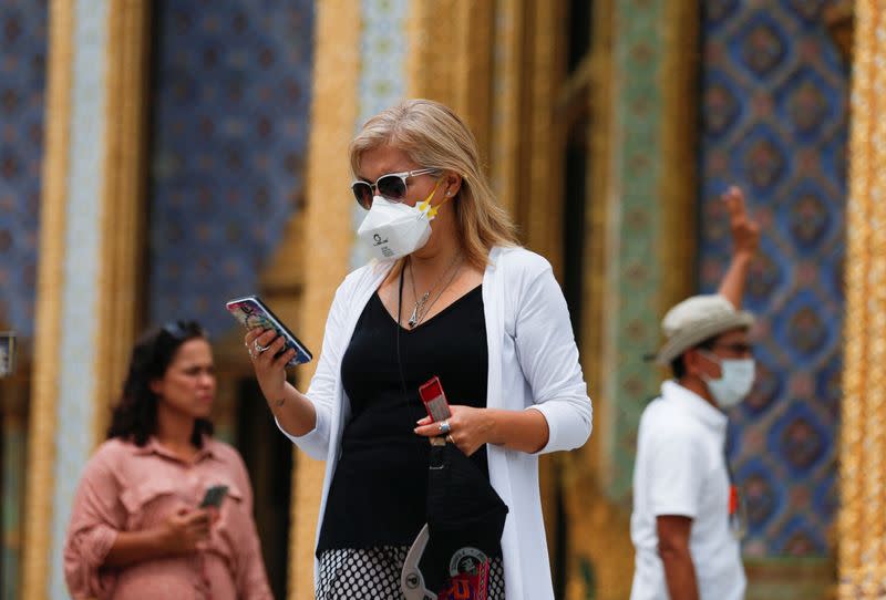 Tourists wear protective face masks at Emerald Buddha temple, which is usually full of tourists, amid fear of coronavirus in Bangkok