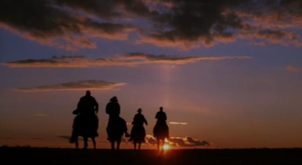 Indiana Jones, Marcus, Sallah and Henry ride their horses toward the sunset