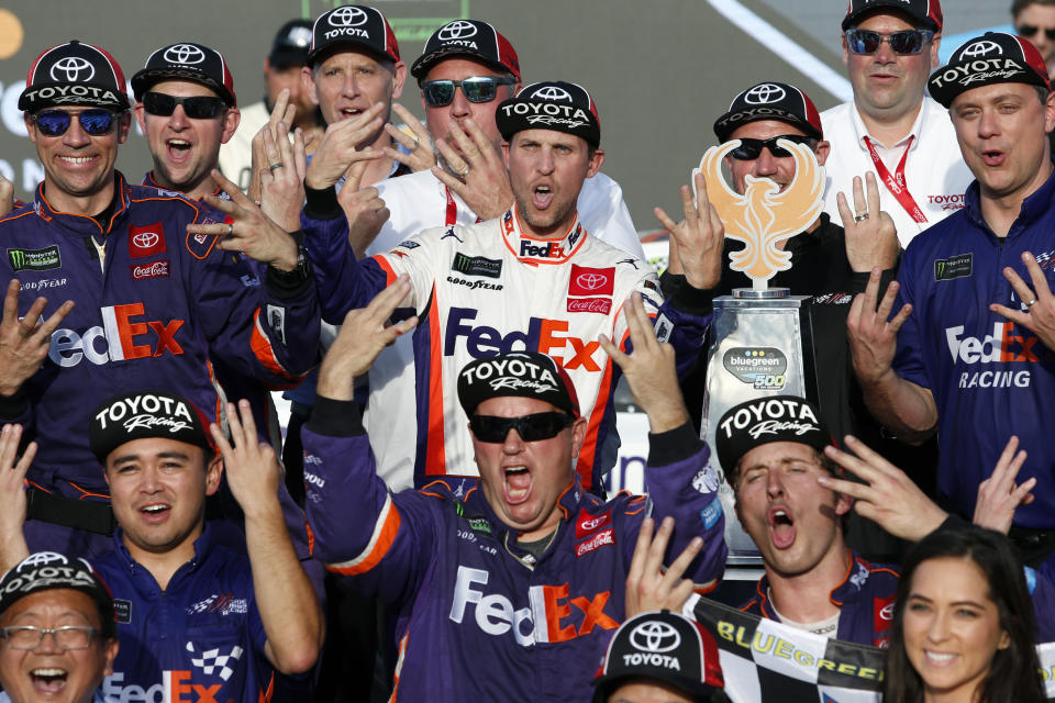 Denny Hamlin, center, and his race team celebrate in Victory Lane after his win in the NASCAR Cup Series auto race Raceway, Sunday, Nov. 10, 2019, in Avondale, Ariz. (AP Photo/Ralph Freso)