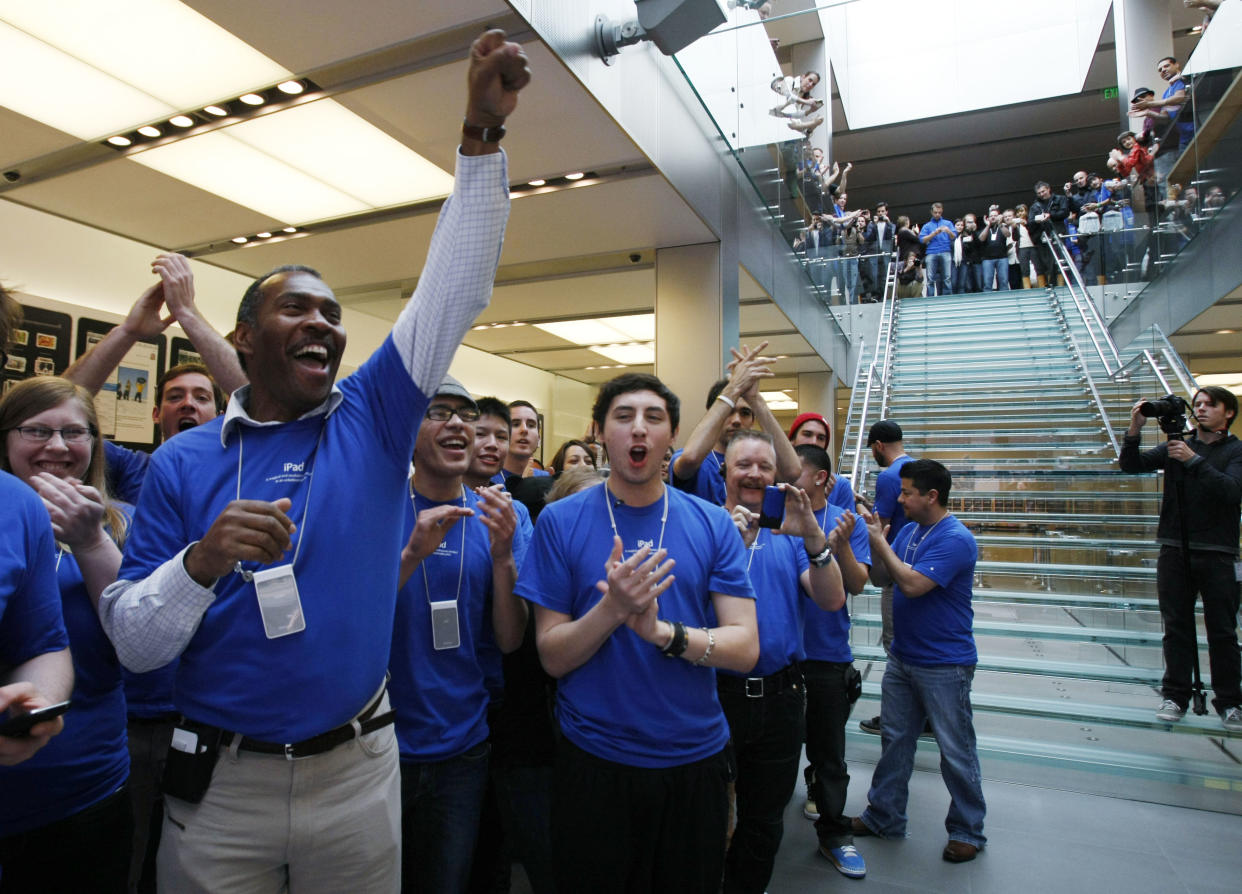 Apple workers cheer as the first iPad customers walk through the door on the first day of Apple iPad sales at an Apple store in San Francisco, Saturday, April 3, 2010. Eager customers have been lining up outside Apple Stores and some Best Buys to be among the first to buy an iPad as sales started at 9 a.m. Saturday in each time zone. (AP Photo/Paul Sakuma)