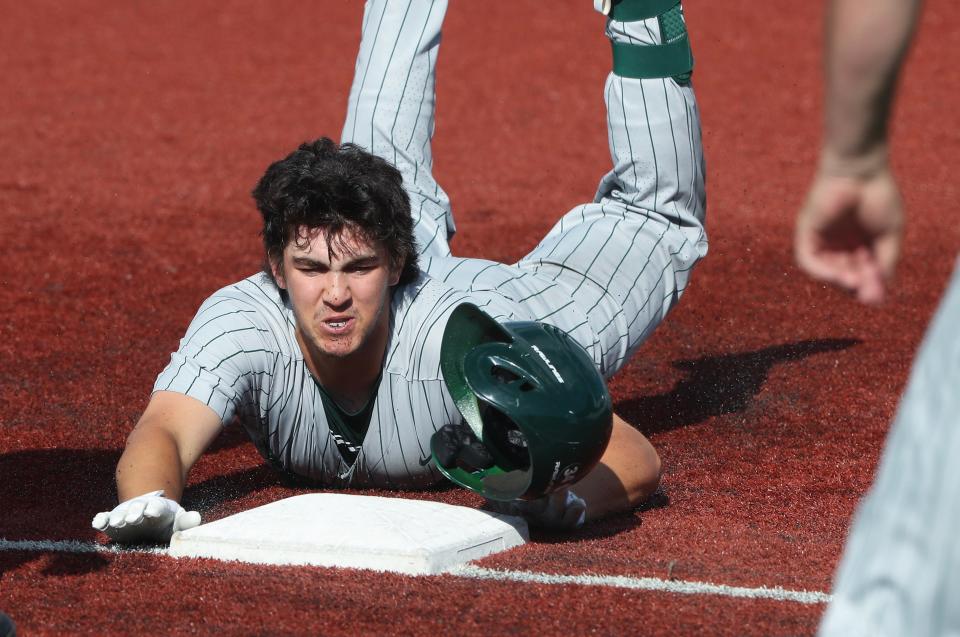 Trinity's Nolan Hosking slides into third base against Manual during the Seventh Region baseball semifinals. The Shamrocks advanced to the state tournament after winning the region.