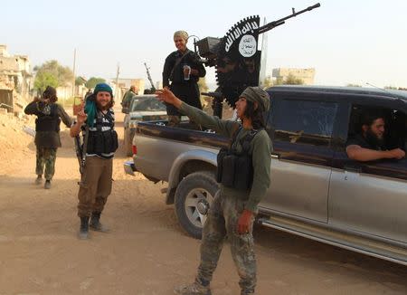 Rebel fighters gesture after they said they took control of Tel Mastouma, which overlooks the Mastouma military base, south of the city of Idlib, Syria May 18, 2015. REUTERS/Ammar Abdullah