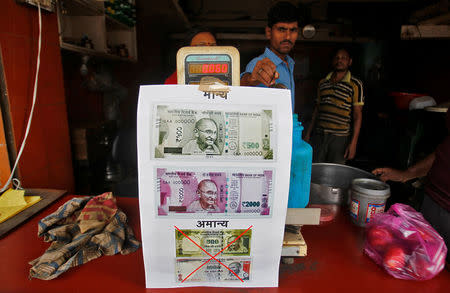 A notice is pasted at a shop stating the refusal of the acceptance of the old 500 and 1000 Indian rupee banknotes and acceptance of the new 500 and 2000 Indian rupee banknotes, in Allahabad, India, November 10, 2016. REUTERS/Jitendra Prakash