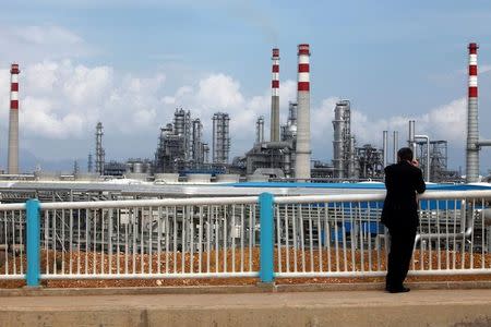 A visitor looks at China National Offshore Oil Corporation's (CNOOC) oil refinery in Huizhou, China's southern Guangdong province July 28, 2009. REUTERS/Tyrone Siu/Files