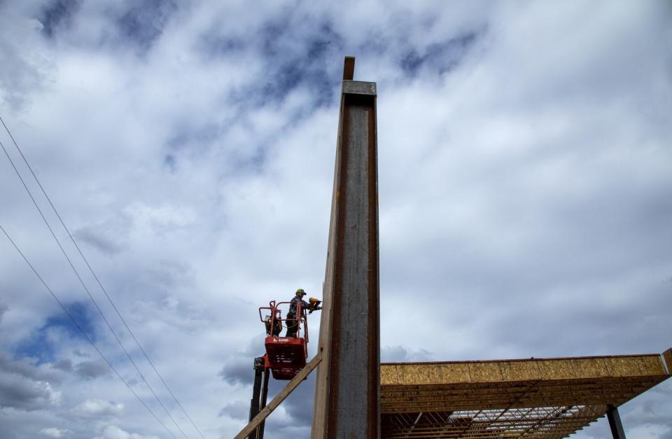 A construction worker nails trusses for a new chip storage shed in Greenville.