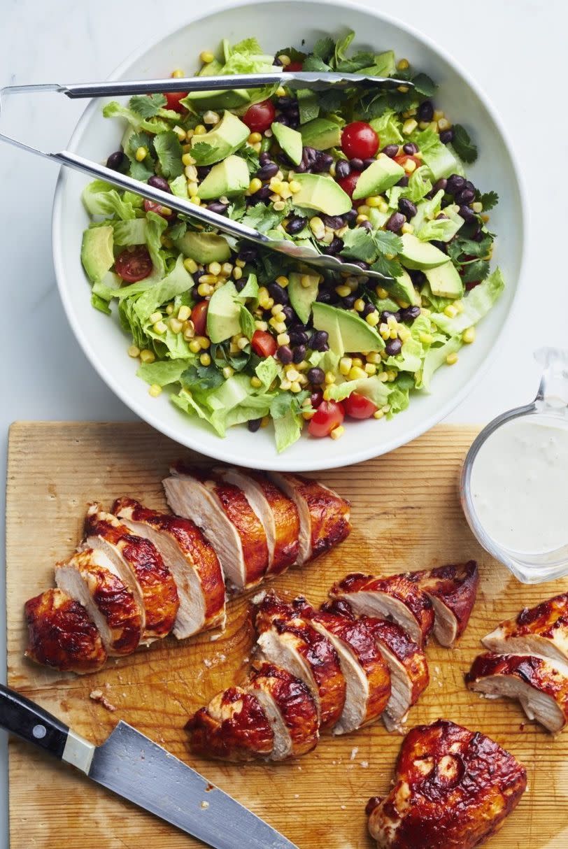 barbecue chicken salad chicken on wood board with salad in bowl