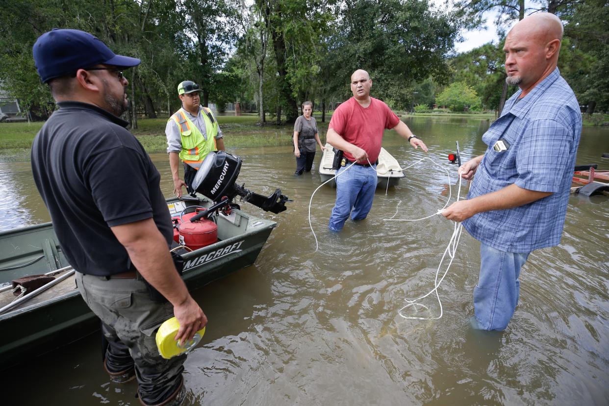 Robert Spooner, a U.S. Customs and Border Patrol officer, center, and other volunteers work to prepare boats to help people in the aftermath of Harvey, Wednesday in Houston. Harvey’s floodwaters started dropping across much of the Houston area, but many thousands of homes in and around the nation’s fourth-largest city were still swamped and could stay that way for days or longer. (Brett Coomer/Houston Chronicle via AP)