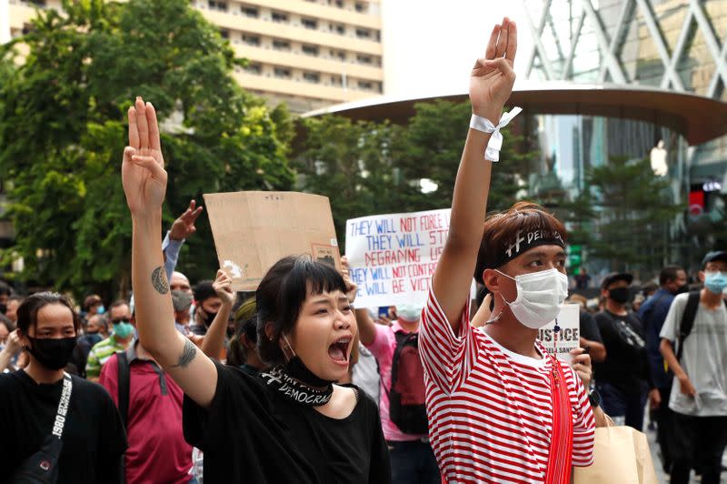 Pro-democracy protesters show the three-finger salute as they gather demanding the government to resign and to release detained leaders in Bangkok