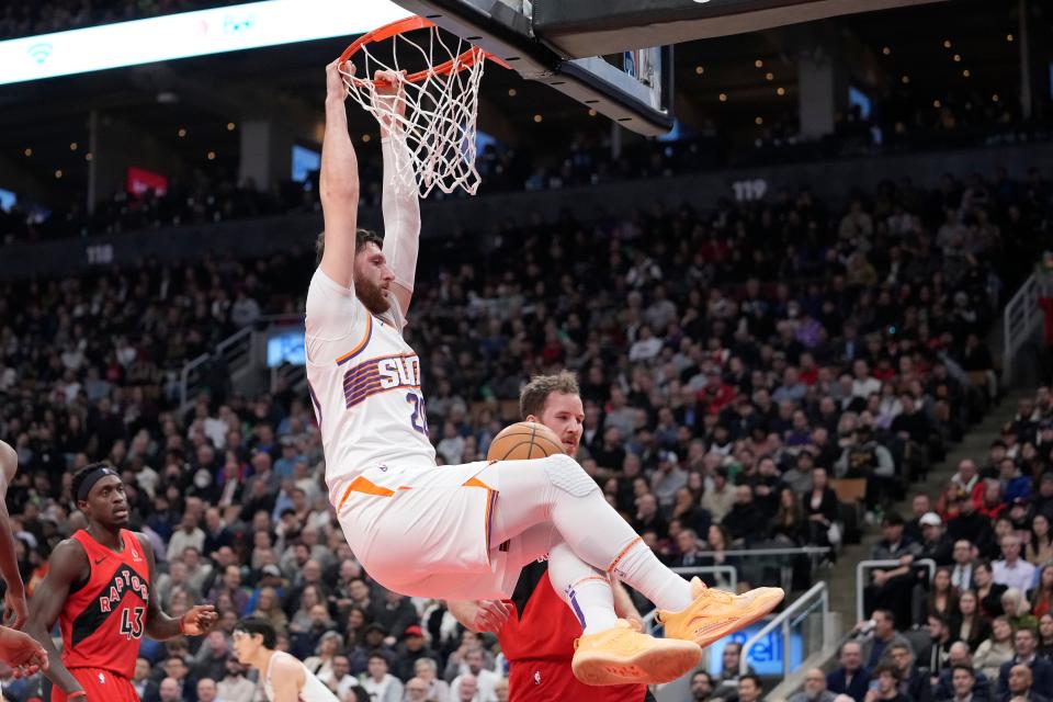Phoenix Suns center Jusuf Nurkic (20) hangs off the rim after dunking against the Toronto Raptors during the first half at Scotiabank Arena in Toronto on Nov. 29, 2023. Mandatory Credit: John E. Sokolowski-USA TODAY Sports