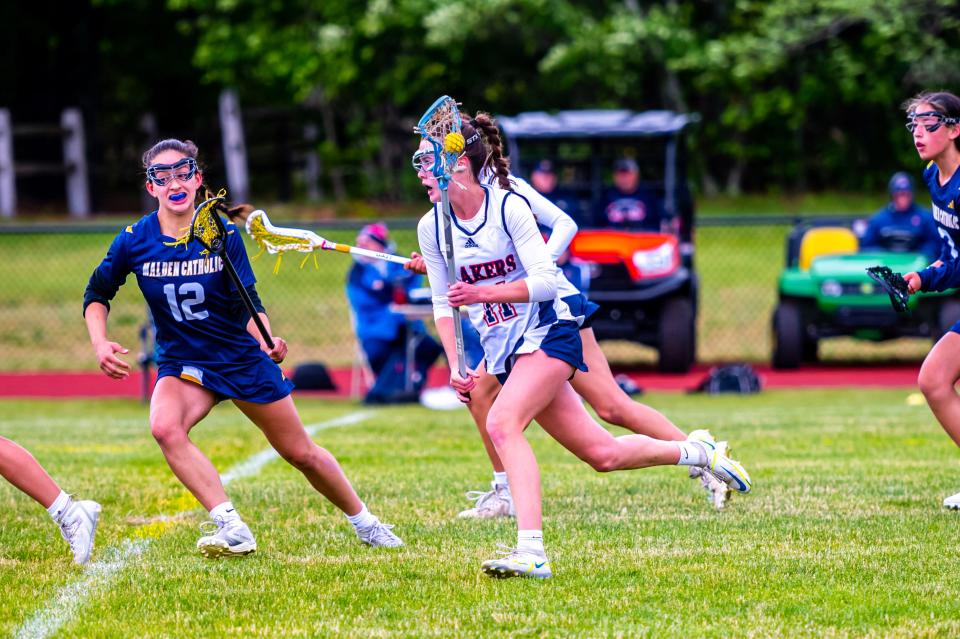 Apponequet's Cece Levrault drives up the field for the Lakers in the MIAA Lacrosse matchup against Malden Catholic.