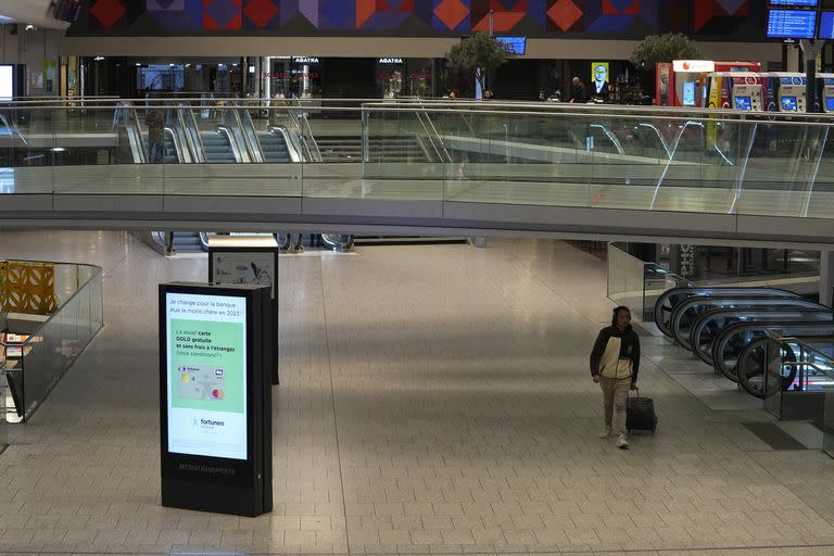 Un viajero solitario camina por la estación de tren de Montparnasse el martes 31 de enero de 2023 en París. La operadora nacional francesa recomendó a los pasajeros que evitaran viajar el martes debido a las huelgas y protestas convocadas contra la reforma de las pensiones. (AP Foto/Michel Euler)