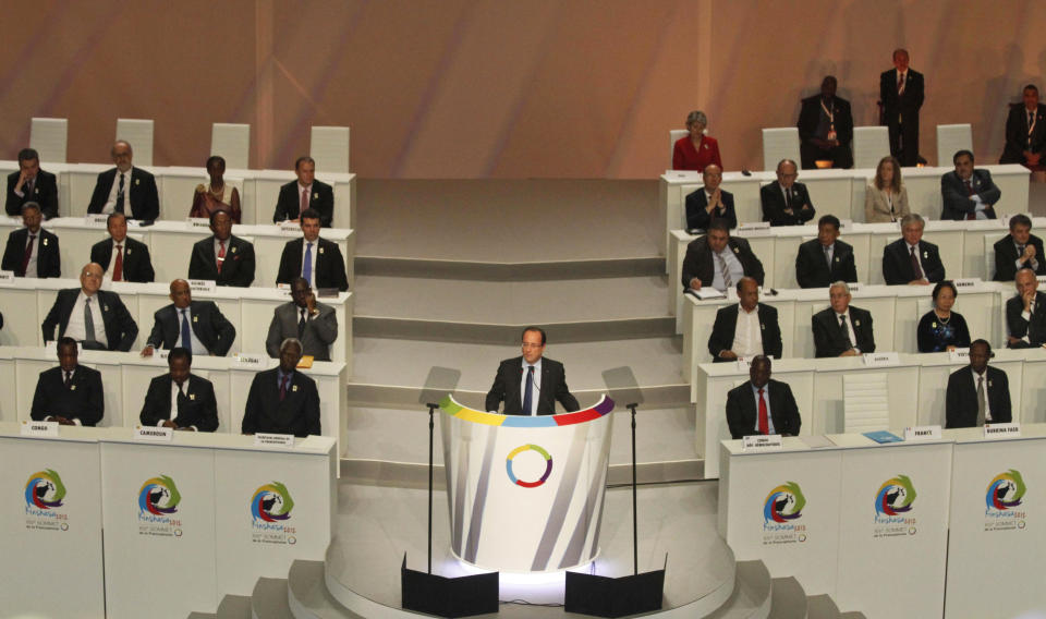 FILE - In this Oct. 13 2012 file photo shot by AP contributing photographer John Bompengo, French President Francois Hollande speaks during the opening session of the Francophonie Summit, in Kinshasa, Democratic Republic of Congo. Relatives say longtime Associated Press contributor John Bompengo has died of COVID-19 in Congo's capital. Bompengo, who had covered his country's political turmoil over the course of 16 years, died Saturday, June 20, 2020 at a Kinshasa hospital. (AP Photo/John Bompengo, file)