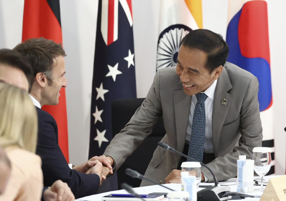 French President Emmanuel Macron, left, and Indonesian President Joko Widodo greet during an outreach session of the leaders of the G7 nations and invited countries, during the G7 Summit in Hiroshima, western Japan, Saturday, May 20, 2023. (Japan Pool via AP)