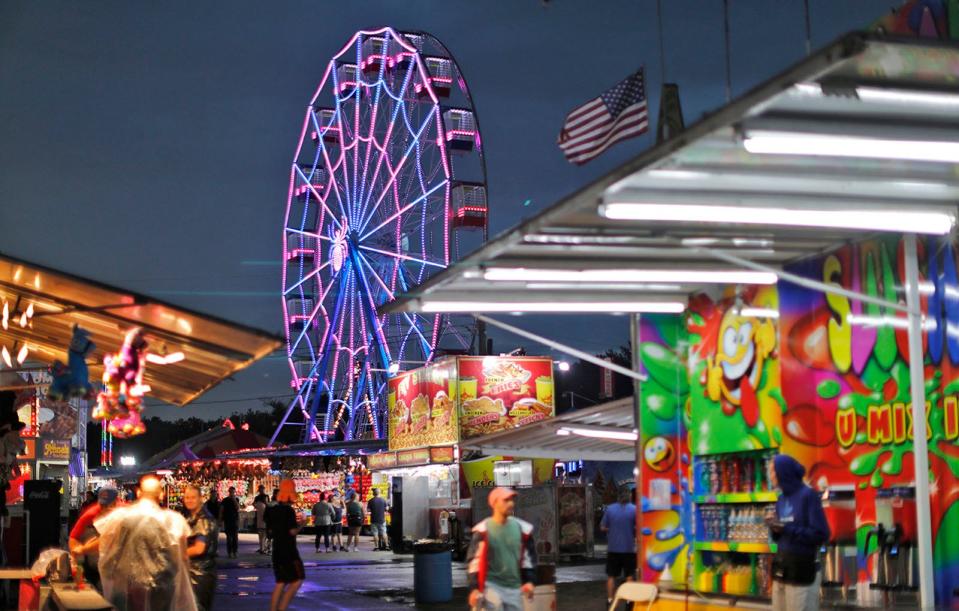 After a summer rain, guests return to the Marshfield Fair in the evening for fun and games Friday, Aug. 26, 2022.