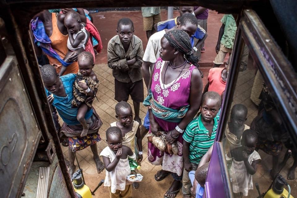 Newly arrived women and children refugees boarding a UNHCR bus at Elegu Collection Point, near the Nimule border -- one of the major entry points into South Sudan. From border entry points, the new arrivals are transported to established transit centers, before being transferred to nearby refugee settlements.&nbsp;<i>Location: Elegu Collection Point, Oct. 27, 2016.</i>