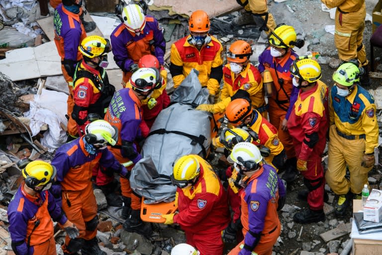 Rescue teams remove a body found in the Yun Tsui building