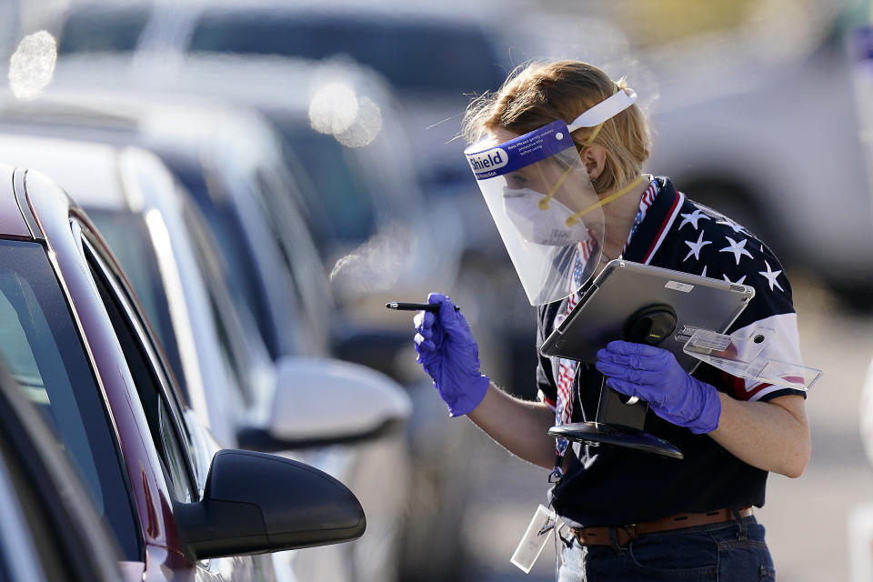 An election worker instructs a voter at a drive-through polling location Tuesday, Nov. 3, 2020, in Kansas City, Mo. The location was established to provide access for people who have tested positive for COVID-19 and elderly voters. (AP Photo/Charlie Riedel)