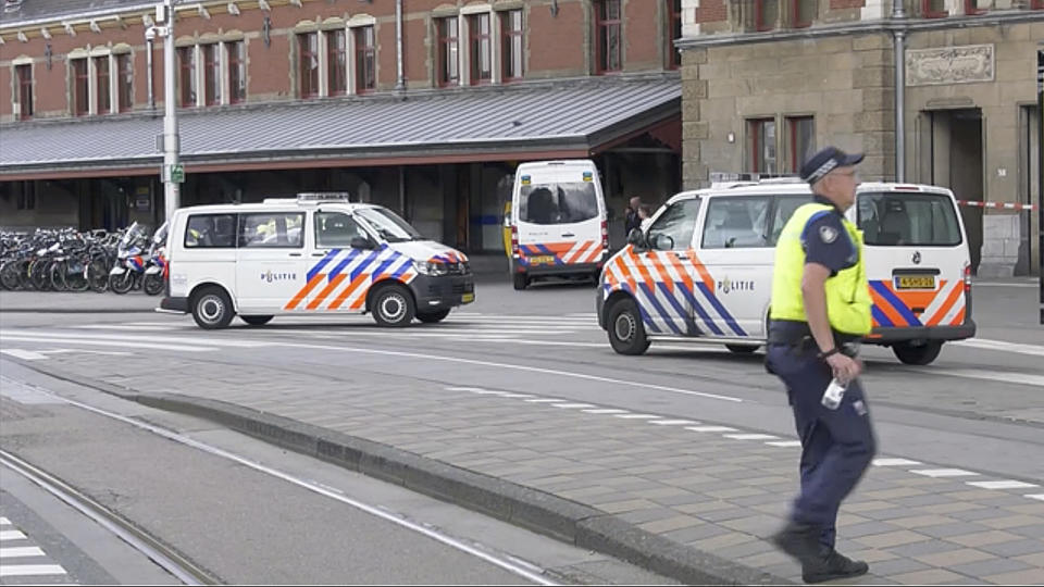 In this image made from video, Dutch police officers stand near the scene of a stabbing attack near the central daily station in Amsterdam, the Netherlands, Friday Aug. 31, 2018. Police the Dutch capital shot and wounded a suspect Friday following a stabbing at the central railway station. Amsterdam police said in a series of tweets that two people were injured in the stabbing and the suspect was then shot by officers. (AP Photo/Alex Furtula)