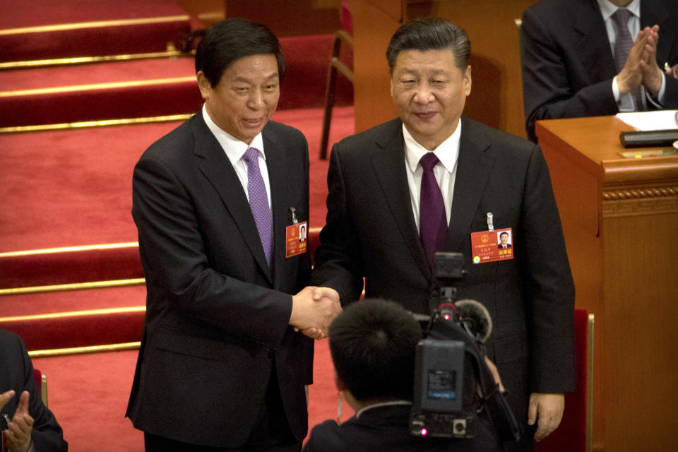FILE - In this March 17, 2018, file photo, Chinese President Xi Jinping, right, poses with Li Zhanshu after Li was elected the new chairman of China's National People's Congress (NPC) during a plenary session of the NPC in Beijing. Xi will not attend celebrations of the 70th anniversary of North Korea's founding this weekend but will send Li, a top ally to represent him instead, the ruling Communist Party announced Tuesday, Sept. 4, 2018. Analysts said a decision by Xi not to travel to Pyongyang would indicate that Beijing expected further actions from North Korean leader Kim Jong Un, including real signs of progress toward denuclearization. (AP Photo/Mark Schiefelbein, File)