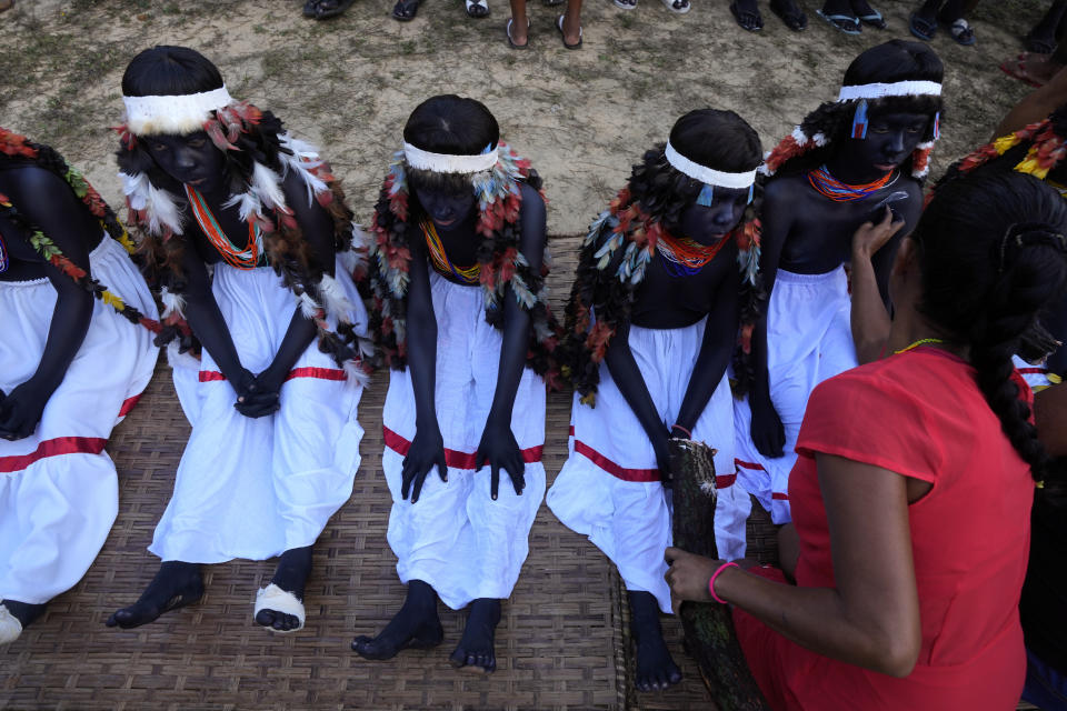 Niñas indígenas se preparan para participar en un ritual durante el último día, el más simbólico, del rito de madurez Wyra'whaw, en el centro ritual Ramada, en la aldea Tenetehar Wa Tembe, en la tierra indígena Alto Río Guamá, en el estado de Pará, Brasil, el 11 de junio de 2023. (AP Foto/Eraldo Peres)