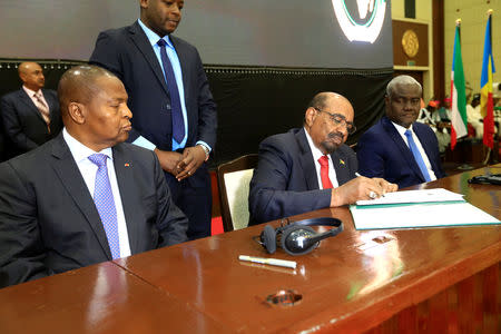 Central African Republic President Faustin-Archange Touadera watches as Sudan's President Omar al-Bashir signs a peace deal between the Central African Republic government and 14 armed groups following two weeks of talks in the Sudanese capital Khartoum, Sudan February 5, 2019. REUTERS/Mohamed Nureldin Abdallah