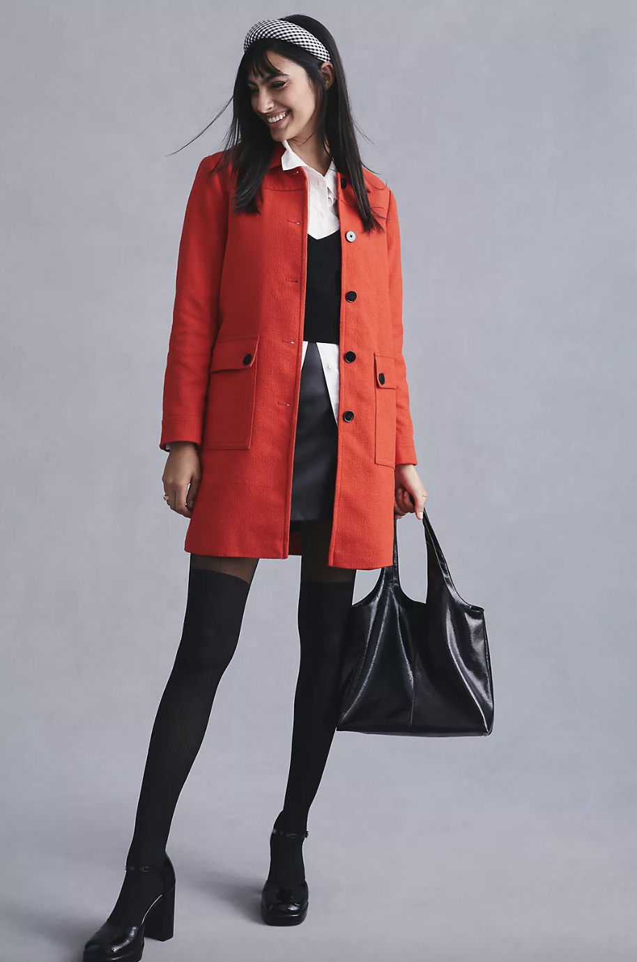 model wearing black tights, black handbag, headband and red Maeve Textured Peacoat in red (Photo via Anthropologie)