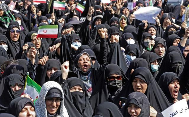 Los iraníes ondean la bandera nacional mientras marchan durante una manifestación pro-hiyab en la capital, Teherán, el 23 de septiembre de 2022.