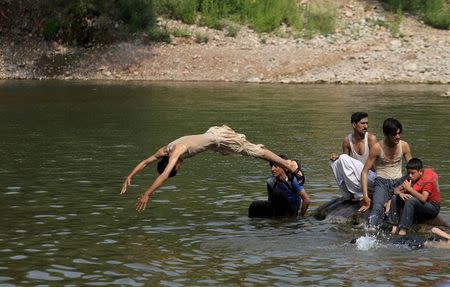 A man jumps in to a stream to cool off during a hot day in Islamabad, Pakistan, June 23, 2015. REUTERS/Faisal Mahmood