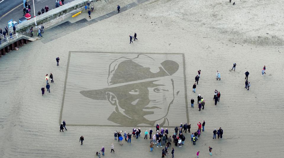 <p>The face of Private Stanley McDougall etched onto the shore at Weymouth Beach, Dorset, as part of Pages of the Sea event. (Finbarr Webster/REX) </p>