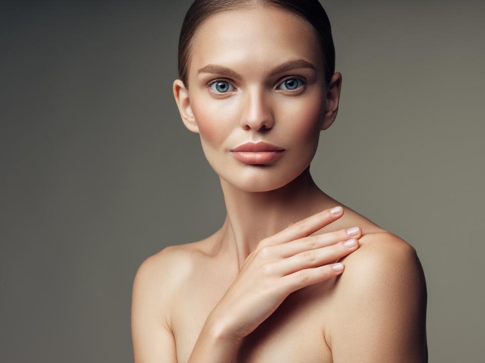 Woman covering her chest with her hand. 