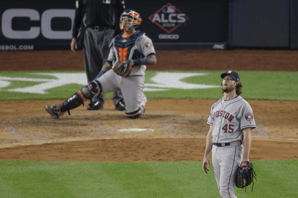 Houston Astros starting pitcher Gerrit Cole (45) and catcher Martin Maldonado watch as a long drive by New York Yankees' Didi Gregorius is caught at the wall by right fielder Josh Reddick with two men on base to end the fifth inning of Game 3 of baseball's American League Championship Series, Tuesday, Oct. 15, 2019, in New York. (AP Photo/Seth Wenig)