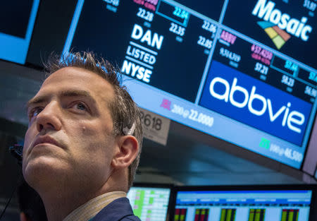 FILE PHOTO: A trader works by the post that trades AbbVie on the floor of the New York Stock Exchange March 5, 2015. REUTERS/Brendan McDermid