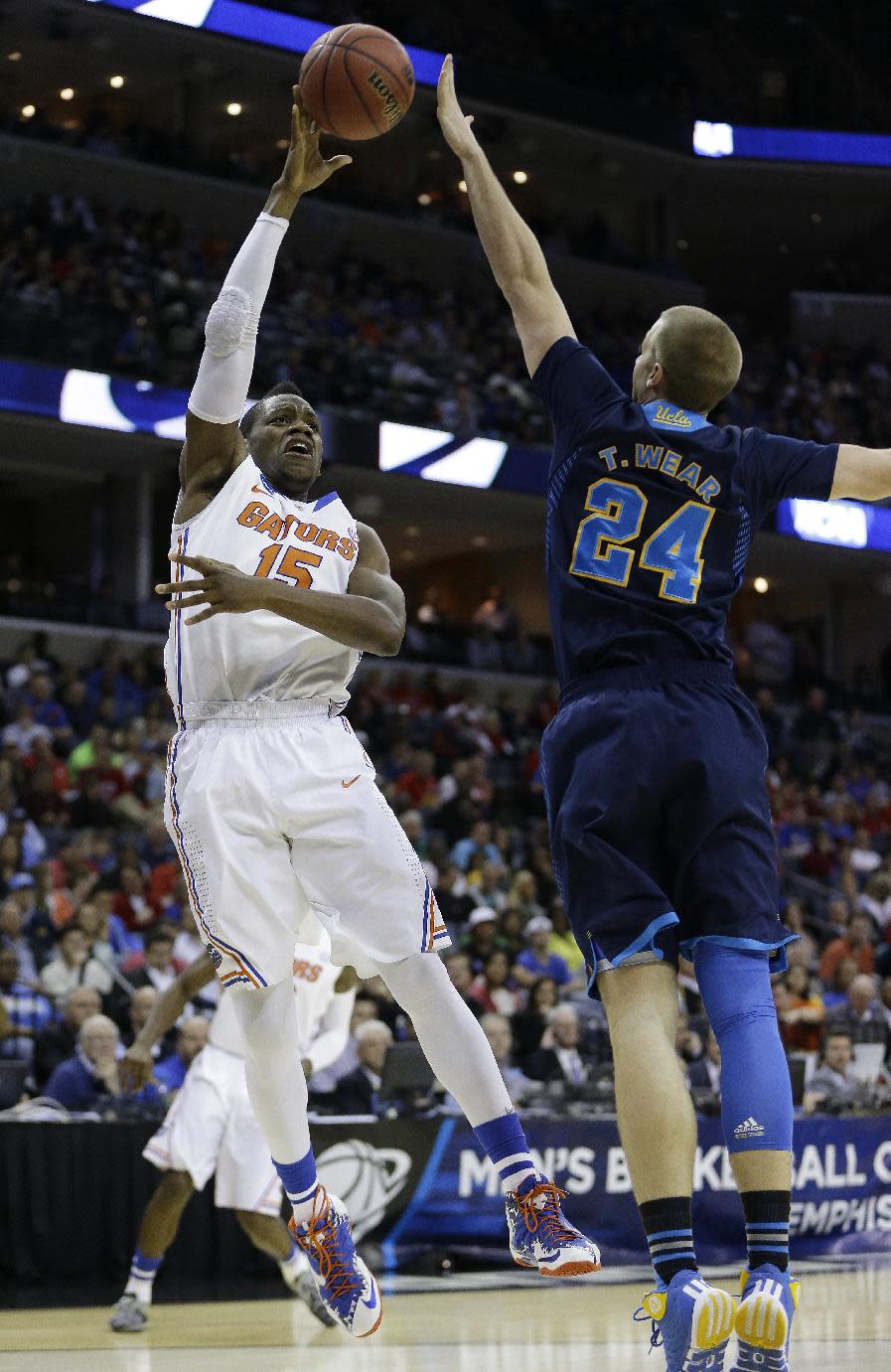 Florida forward Will Yeguete (15) shoots over UCLA forward Travis Wear (24) during the first half in a regional semifinal game at the NCAA college basketball tournament, Thursday, March 27, 2014, in Memphis, Tenn. (AP Photo/Mark Humphrey)