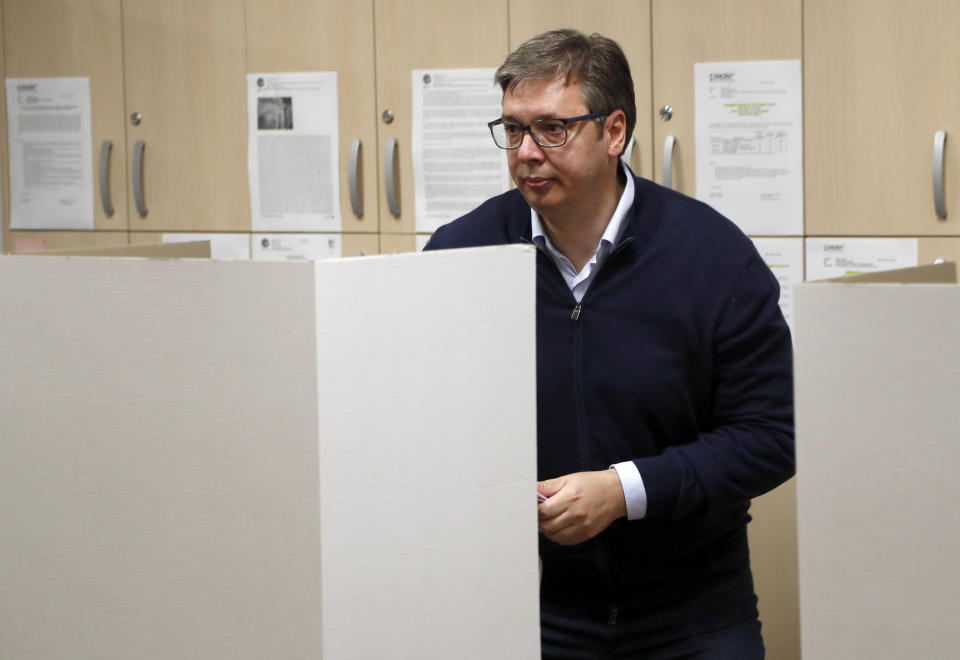 Serbia's President Aleksandar Vucic prepares to vote, at a polling station, in Belgrade, Serbia, Sunday, June 21, 2020. Serbia's ruling populists are set to tighten their hold on power in a Sunday parliamentary election held amid concerns over the spread of the coronavirus in the Balkan country and a partial boycott by the opposition. (AP Photo/Darko Vojinovic)