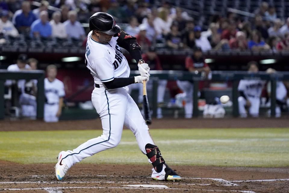 Arizona Diamondbacks' Christian Walker starts his swing on a three-run home run against the San Francisco Giants during the third inning of a baseball game Tuesday, July 26, 2022, in Phoenix. (AP Photo/Ross D. Franklin)