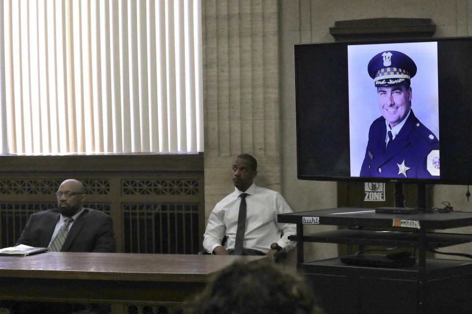 An image of Chicago Police Commander Paul Bauer during closing statements in Shomari Legghette's, left, murder trial at the Leighton Criminal Courthouse, Friday, March 13, 2020, in Chicago. Legghette is on trial for first-degree murder in the Feb. 13, 2018, killing of Chicago Police Cmdr. Paul Bauer. (Antonio Perez/Chicago Tribune via AP)