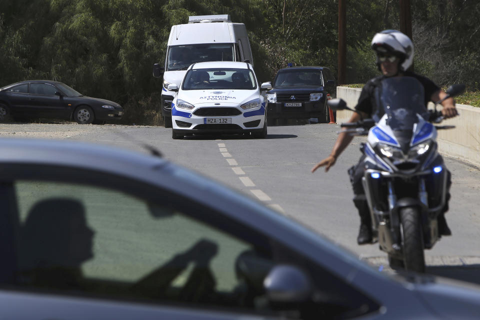 A motorcyclist police officer escorts and guards the police van carrying Army Captain Nicholas Metaxas from the court to the Cypriot central prison in capital Nicosia, Cyprus, Monday, June 24, 2019. A Cypriot army captain on Monday tearfully apologized to the families of seven foreign women and girls for the "unjust pain" he has caused them after pleading guilty to a dozen charges of premeditated murder and kidnapping. (AP Photo/Petros Karadjias)
