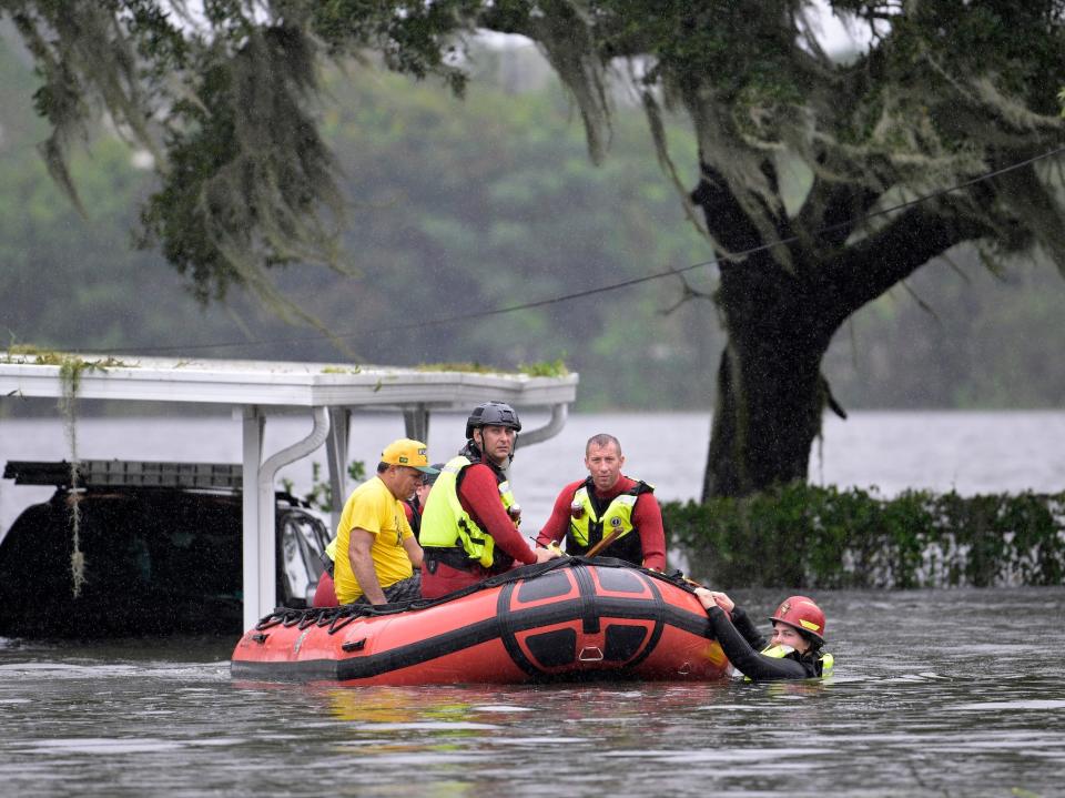 first responders in an inflatable lifeboat in floodwaters