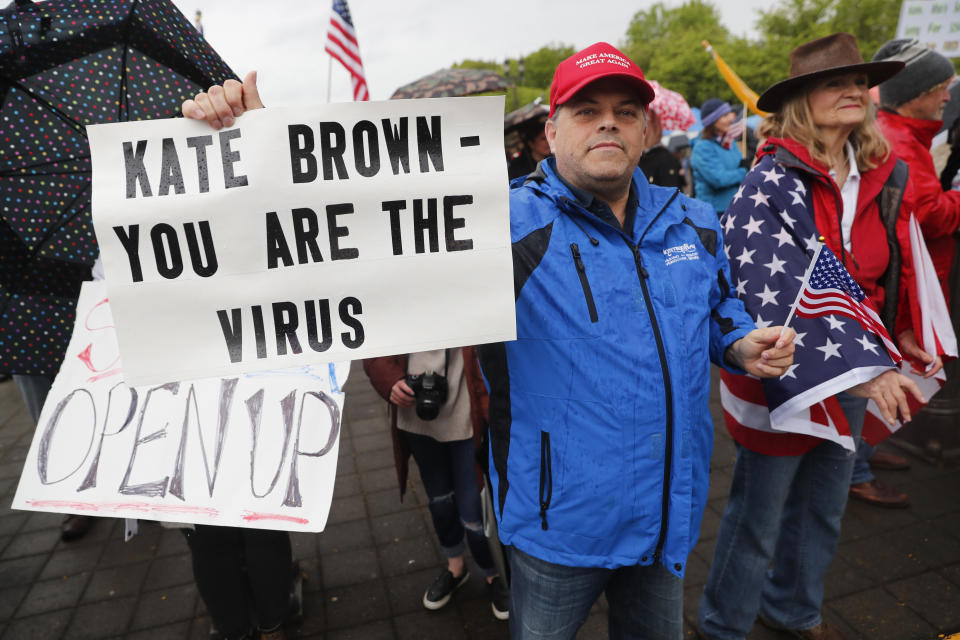 SALEM, OR - MAY 02: A man holds a sign saying Kate Brown you are the virus at the ReOpen Oregon Rally on May 2, 2020 in Salem, Oregon. Demonstrators gathered at the state capitol to demand a reopening of the state and to protest Gov. Kate Brown's stay-at-home order which was put in place to slow the spread of the coronavirus (COVID-19). (Photo by Terray Sylvester/Getty Images)