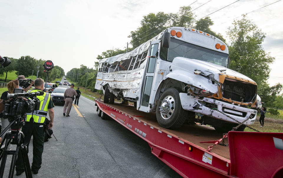 A bus is removed after it collied with a small pickup truck killing eight of the more than 50 migrant workers in the bus, Tuesday, May 14, 2024, in Ocala, Fla. The driver of the pick up, Bryan Maclean Howard, was charged with eight counts of DUI manslaughter. (AP Photo/Alan Youngblood)