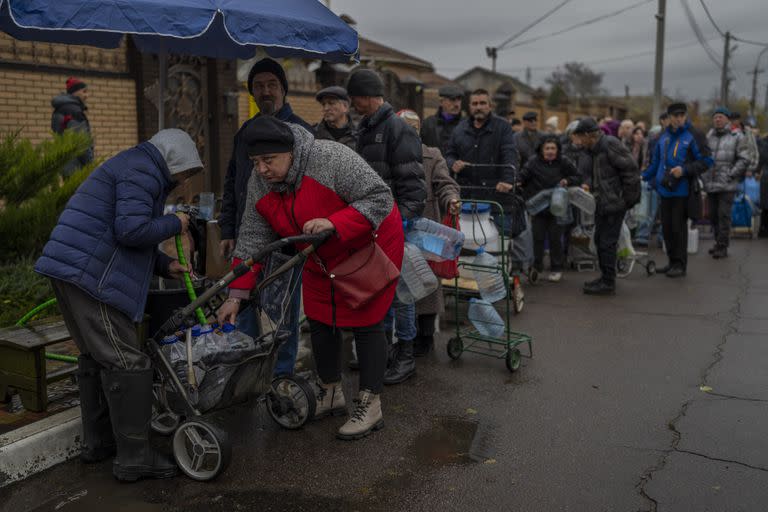 Los residentes hacen cola para llenar contenedores con agua potable en Kherson, sur de Ucrania, el domingo 20 de noviembre de 2022.