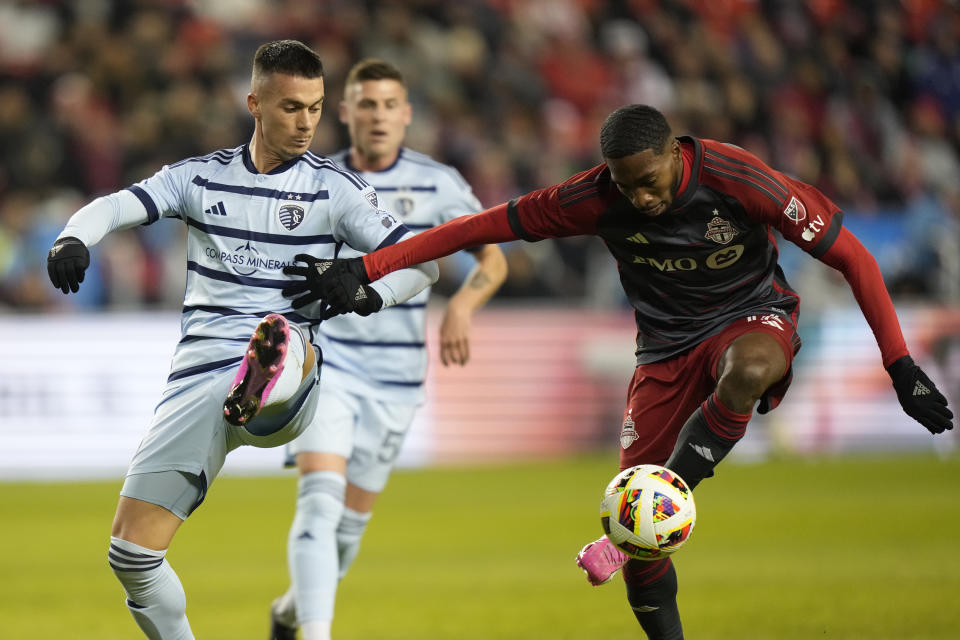 Toronto FC midfielder Tyrese Spicer, right, controls the ball as Sporting Kansas City midfielder Erik Thommy (26) defends during the first half of an MLS soccer game in Toronto, Ontario, Saturday, March 30, 2024. (Frank Gunn/The Canadian Press via AP)