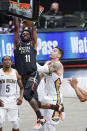 Brooklyn Nets' Kyrie Irving (11) dunks the ball in front of New Orleans Pelicans' Eric Bledsoe (5) and Willy Hernangomez (9) during the first half of an NBA basketball game Wednesday, April 7, 2021, in New York. (AP Photo/Frank Franklin II)